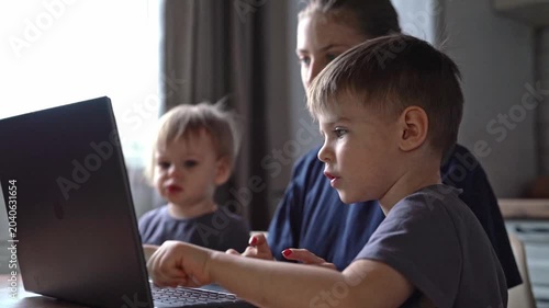 White caregiver guiding kids through laptop activity at wooden table, hands on trackpad, lively expressions, focused lesson, breakfast nook ambience, casual clothes, engaged teaching, subtle