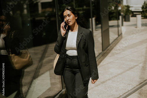 Businesswoman walks and tal...