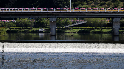 Urban River Landscape with Modern Bridge, Weir for Water Flow Control, and River Ecosystem Support
