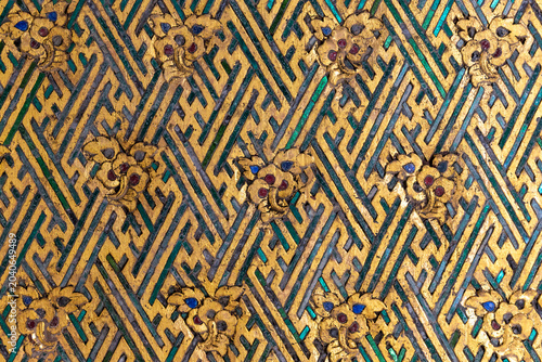 фотографія Traditional Thai golden pattern with green glass mosaic inlay decoration on a wall surface