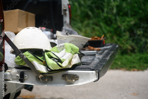 Cuadro en lienzo White Hard Hat and Safety Vest on Pickup Truck Tailgate at Construction Worksite