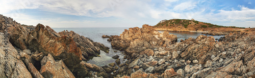 Cala Balimedda cove at Golfo Aranci rocky shore panorama, sea in background