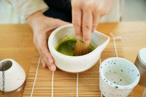 Preparing traditional Japanese matcha green tea with a bamboo Chasen
