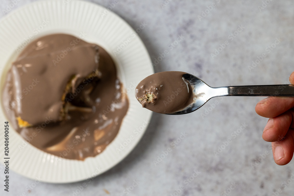 Fototapeta premium Eating Chocolate Covered Sponge Cake