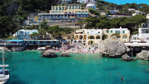 Cinematic aerial view of Capri Marina Piccola with boats and coastal cliffs