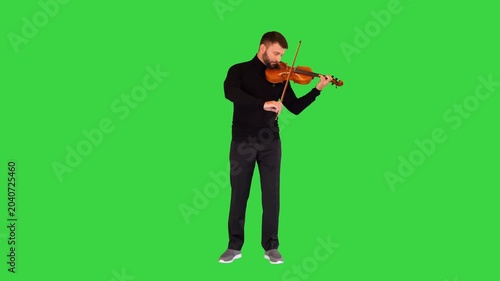 Inspired male musician plays classical composition on the violin on a Green Screen, Chroma Key.