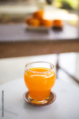 Fresh orange juice in a glass on a white table