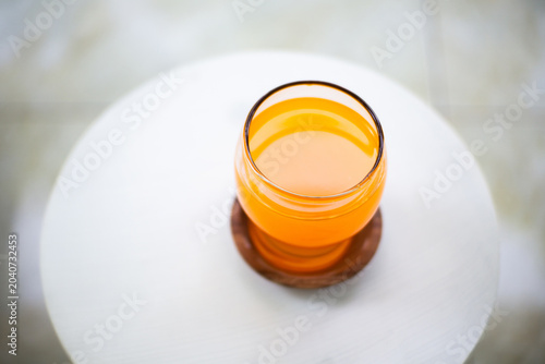 Fresh orange juice in a glass on a white table