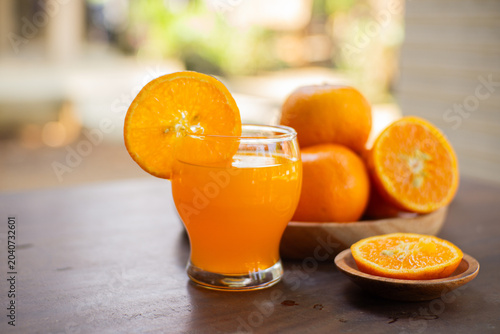 Fresh mandarin oranges and citrus juice in a glass, showcasing natural vitamin-rich refreshment with vibrant colors and healthy appeal