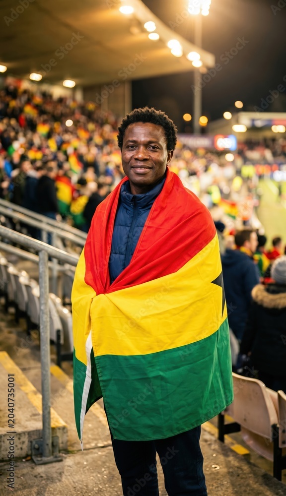 Fototapeta premium Ghana football supporter wrapped in national flag at stadium