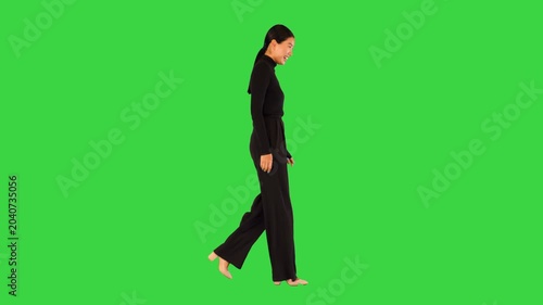 Modest asian girl walks smiling and laughing on a Green Screen, Chroma Key.