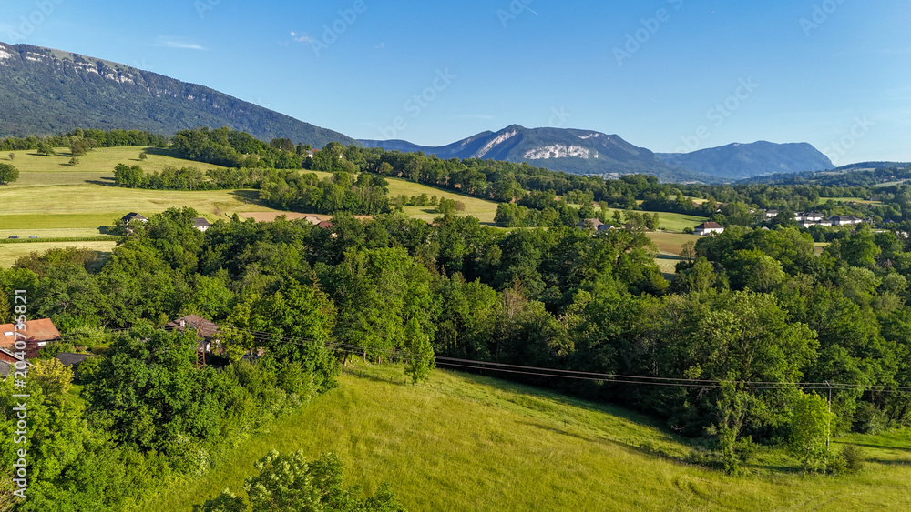 Obraz premium Vue aérienne des paysages vallonnés et montagnes des Alpes en Haute-Savoie