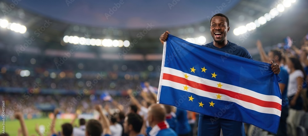 Fototapeta premium Cape Verde football fan celebrating with national flag in stadium