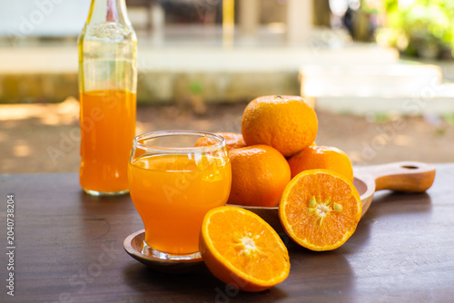 Fresh mandarin oranges and citrus juice in a glass, showcasing natural vitamin-rich refreshment with vibrant colors and healthy appeal
