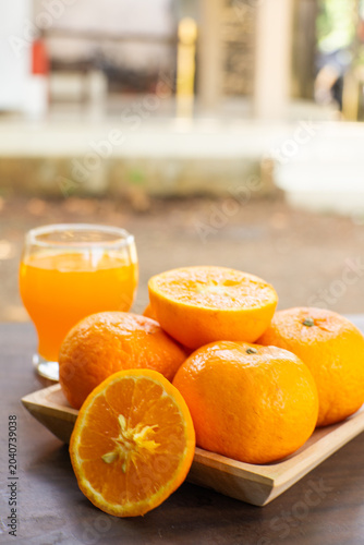 Fresh mandarin oranges and citrus juice in a glass, showcasing natural vitamin-rich refreshment with vibrant colors and healthy appeal