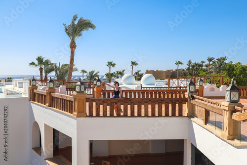 Traveler Woman Enjoying Breathtaking Sea View from Spacious Balcony of Egyptian Hotel, Embracing the Serenity Nature and Adventure.