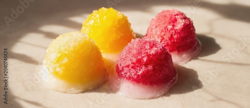 Colorful frozen treats vibrant yellow and red overhead view on a neutral surface