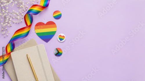 Rainbow pride heart notebook ribbon badge button lgbt equality celebration Colorful rainbow pride heart with notebook, pen, ribbon and badges pastel purple background creating joyful lgbt equality
