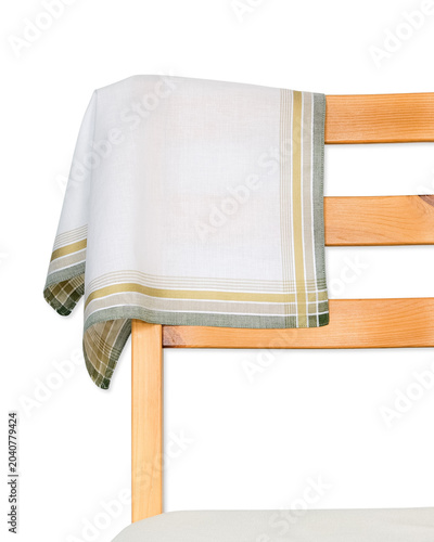 A white cotton handkerchief accented with olive green and gold striped borders draped over the back of a wooden chair isolated on a white background.