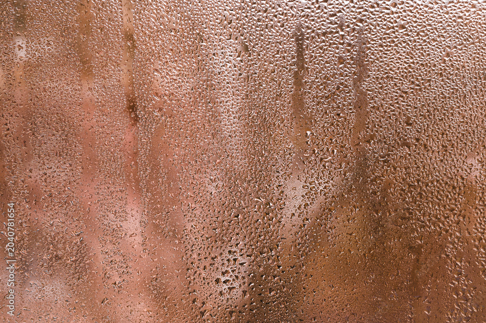 Fototapeta premium Condensation on window glass forming wet pattern, droplets reflecting diffused light, closeup detail of wet surface, abstract urban and natural background concept