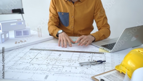 Architect developing an innovative property design from blueprints to a detailed architectural scale model, planning real estate projects and urban infrastructure development