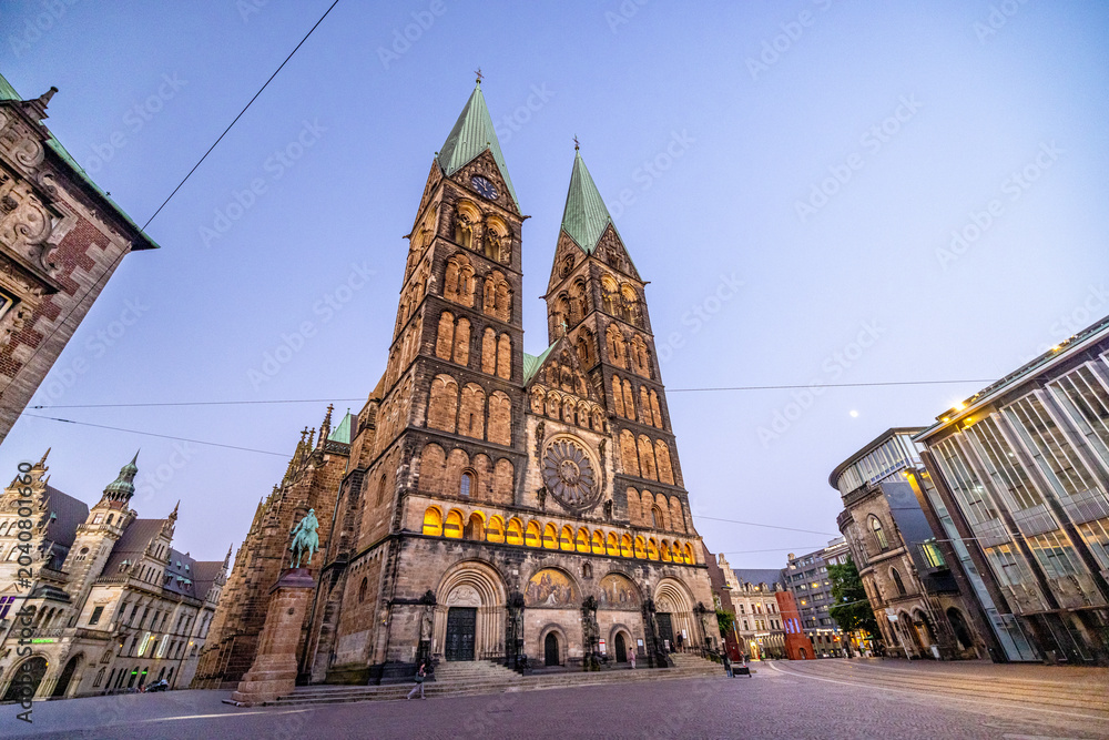 Fototapeta premium Bremen by night, with glowing streets, historic facades, and reflections creating a peaceful urban atmosphere in the heart of northern Germany.