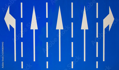 Blue road sign with white traffic direction arrows