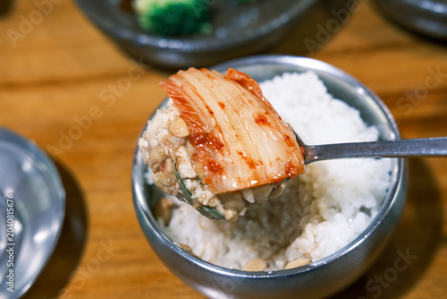 Photography ​A spoonful of rice mixed with Korean rich soybean paste stew, topped with Kimchi