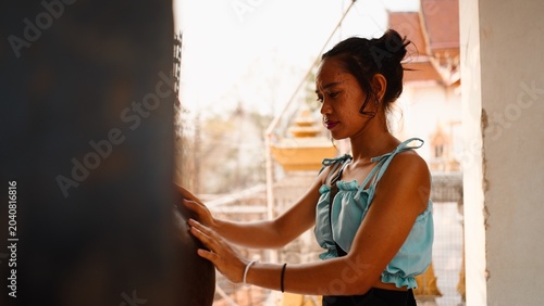 Foto Thai woman touching sacred temple bell, finding spiritual connection during medi