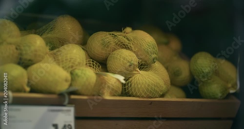 Lemons in protective net packaging displayed in a wooden crate at a store in Zagreb Croatia.