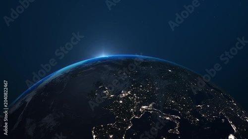 Cinematic view of planet Earth from orbit with glowing atmosphere, city lights and sunrise over the horizon. Realistic space scene featuring the curvature of the planet, clouds, stars and illuminated 