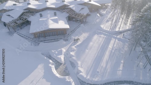 Drone advancing downward over winter hotel