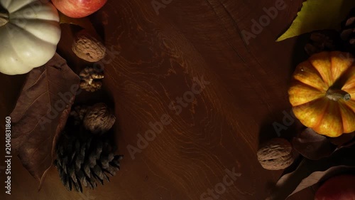 Simple rustic design. Clean framing style incorporating gourds and seasonal foliage on surface. Elegant border composition highlighting seasonal gourds and leaves arranged on wooden background