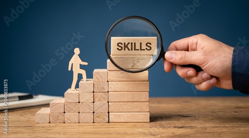 Professional analyzing career skills growth with magnifying glass on wooden blocks at desk