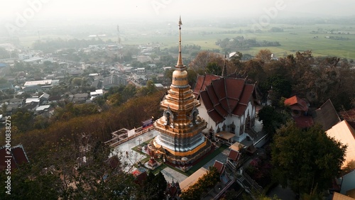 Canvastavla Golden chedi on a hill overlooking chiang mai town and rice fields in thailand