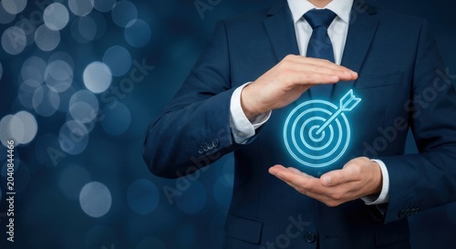 Businessman protecting a target icon, symbolizing goal achievement, strategic planning, business success, performance management, growth objectives and corporate leadership. Copy space