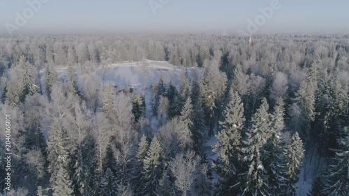 Drone advancing over snowy canopy towards hotel