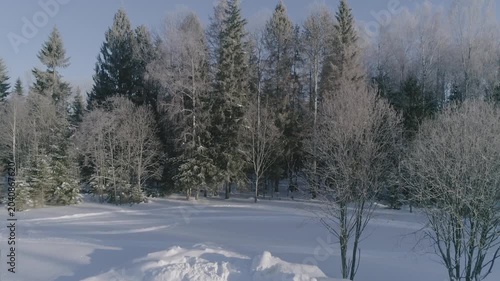 Drone takeoff forward over snowy canopy