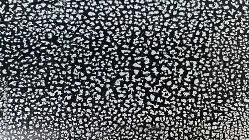 Cuadro en lienzo Close-up of cracked paint texture forming irregular white patches on dark base,