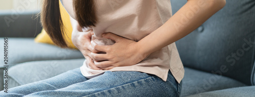 Obraz na plátne asian young woman intolerance hand in stomach ache, suffer from food poisoning,