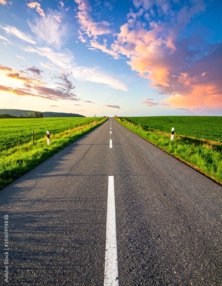 Naklejka premium Endless road under sunset sky