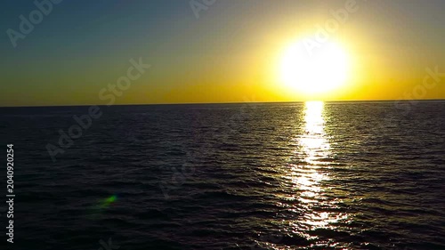 Bright sunset over the black calm ocean. Exotic adventure vacation, sunset footage from the liveaboard tourist ship. Orange and dark sea water.