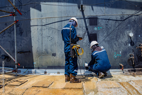 Male two worker inspection scan weld defect tank of rust thickness bottom plate