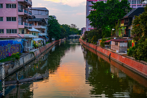 Canal in Bangkok with residential buildings at sunset