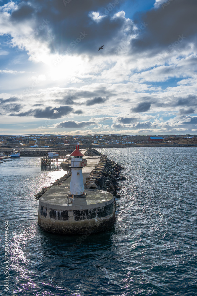 Obraz premium Lighthouse of norwegian town Vardo with blue sea and clouds in the background