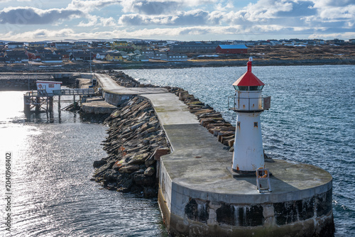 Lighthouse of norwegian town Vardo with blue sea and clouds in the background