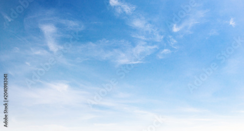 Clear blue sky with wispy clouds drifting gently