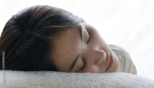 Peaceful woman sleeping on soft pillow in bright serene bedroom