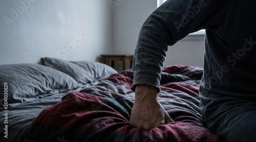 A Person's Hand Resting Down on Comforter In Bedroom During The Daytime