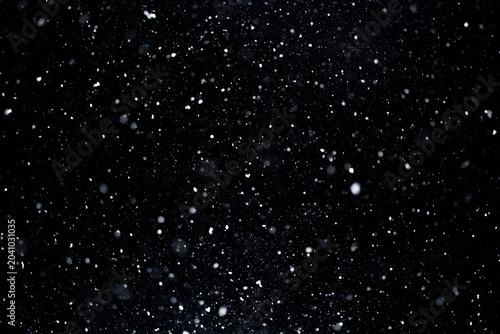 Snowflakes falling slowly in winter air. Snow overlay template with floating snow. Realistic snowfall particles on dark backdrop. Snowstorm effect with intense motion. Snow texture overlay.